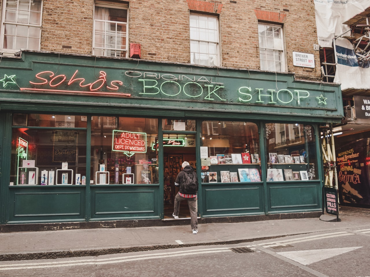 The interior of Margins Bookshop, with tall wooden shelves, a reading chair and warm lamplight.